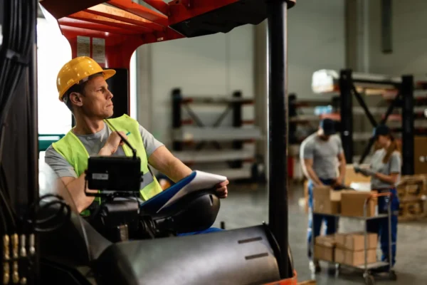 Warehouse worker manually lifting a box, demonstrating a high-risk activity that contributes to elevated wearhouse injury rates.