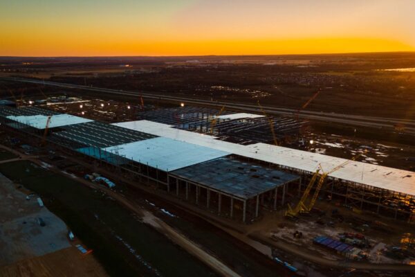 Specialized EV battery plant material handling equipment safely positioning a heavy lithium-ion battery pack on an automated assembly line
